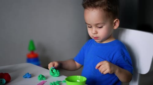 Boy Creatively Playing With Colorful Clay Indoors