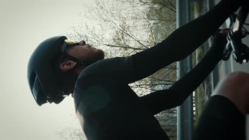Professional cyclist in helmet and cycling clothes riding bicycle.Vertical video