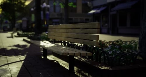 Empty Wooden Bench in a Quiet Urban Plaza During Golden Hour