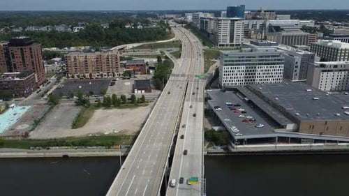 Traffic Drives Along Two Intersecting Highways Dividing A Metropolitan City With Tall Business And R