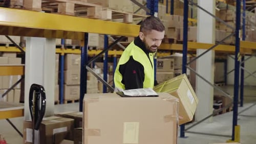 Männlicher Lagerarbeiter beim Laden von Kisten