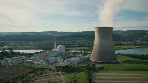 Aerial drone view of nuclear power station with cooling tower. Vertical video
