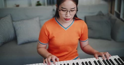 Young Woman Plays Piano in Home