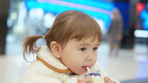 Little Girl Drinking Juice At The Shopping Mall. closeup