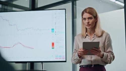 Woman Presenting Financial Data with Tablet in Office
