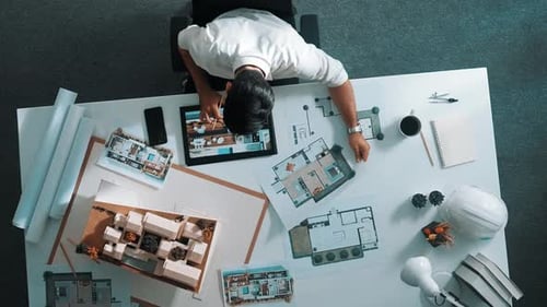 Ansicht von oben auf einen intelligenten Geschäftsmann, der ein Tablet verwendet, um das Hausdesign zu planen. Ernährung.