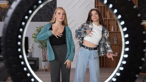 Two Young Women Dancing in Front of Ring Light