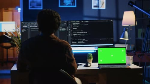 Programmeur codant sur un ordinateur à côté d'un ordinateur portable à écran isolé au bureau à domicile