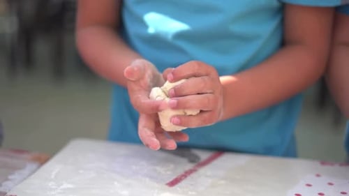 Kochkurs. Kinder stellen in der Schule Brotteigformen her. Ansicht der Hände in Zeitlupe