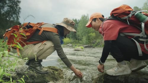 Asian Female Tourists Washing Hands in River