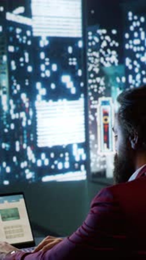 Man Works at Laptop in City Office at Night