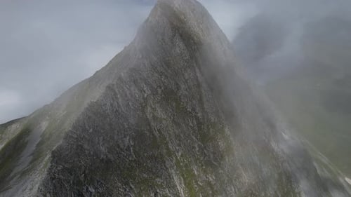 mountain peak in the Austrian alps shot on drone covering clouds and blue sky