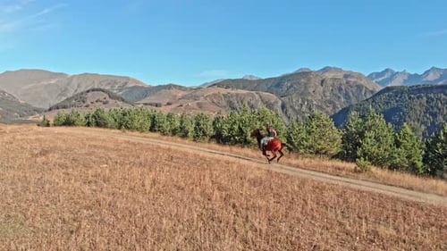 Kaukasischer Reiter reitet Pferd im Bergtal