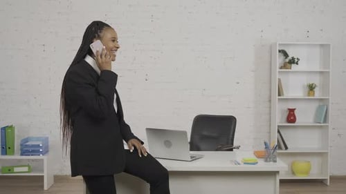 Stylish Woman in Suit Using Phone in Office