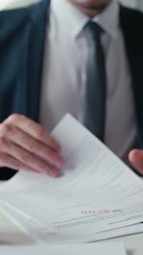 Man Stamping Rejected on Document in Workplace