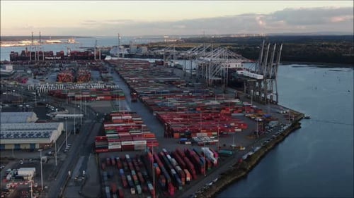 Foto aérea de drone do Porto de Southampton. Terminal de contêineres movimentado com navios e guindastes.
Como