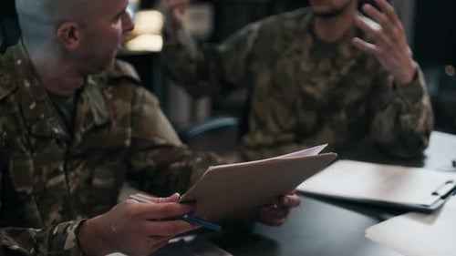 Commanders in Uniform Discussing Documents in Military Hub