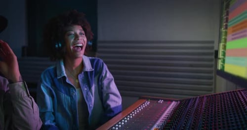 Music Engineers Working Together in Studio at Night