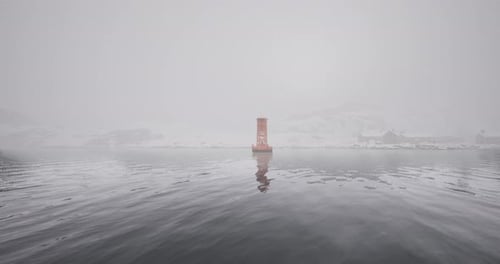 Paisaje invernal brumoso con una sola boya en aguas serenas y heladas