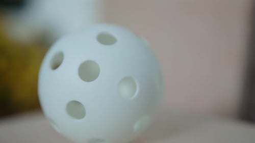 White Floorball Ball on Wooden Surface