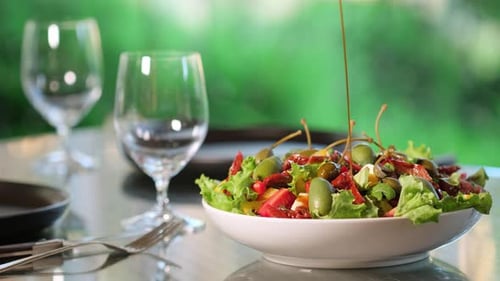 Dressing fresh salad with balsamic vinegar. Healthy food concept