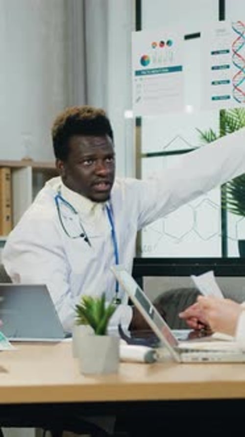 Doctor Explains Data to Colleague in Meeting
