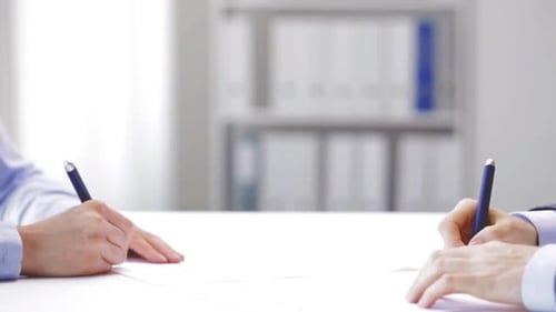 Business people sealing the deal with a handshake after signing contract in office