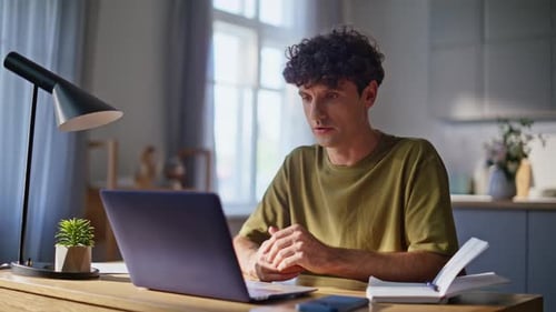 Man Working at Home at Computer, Taking Notes