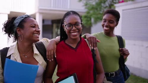 Retrato: Jovens alegres e simpáticas colegas de classe, apoiando-se umas nas outras e olhando para a câmera ao ar livre