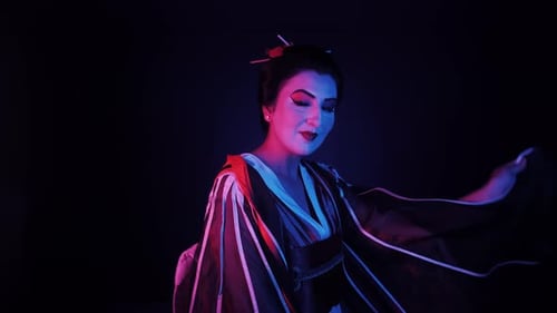 Geisha im fließenden Kimono unter Neonlicht im Studio, Porträt einer Japanerin in traditionellem Kostüm