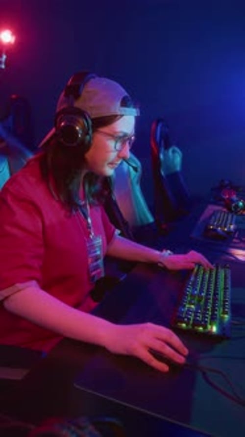 Une adolescente geek caucasienne joue à un jeu vidéo en ligne dans un cyberclub