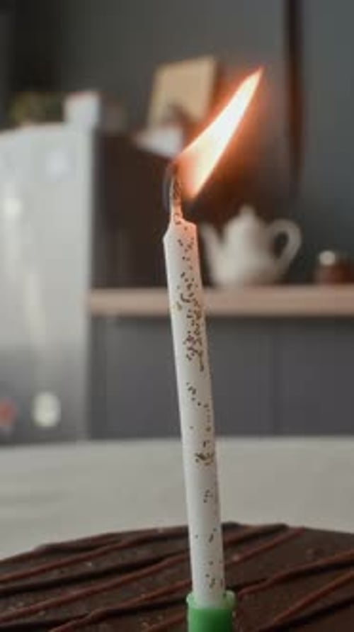 Burning Candle is Blown Out on Birthday Cake