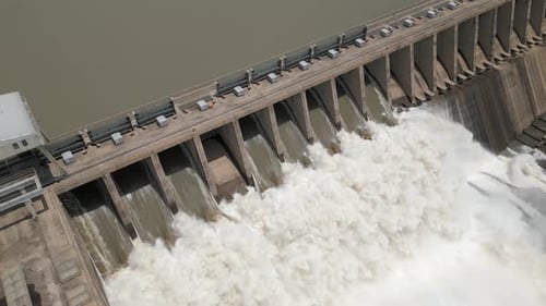 Aerial view of hydro electric dam releasing turbid flood water