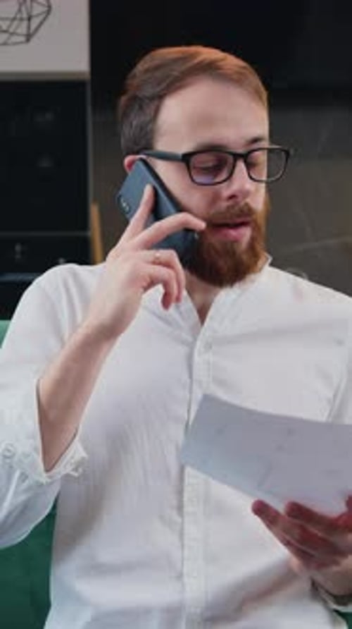 Man Working with Documents at Remote Workplace Business Man Talking Mobile Phone and Revisioning