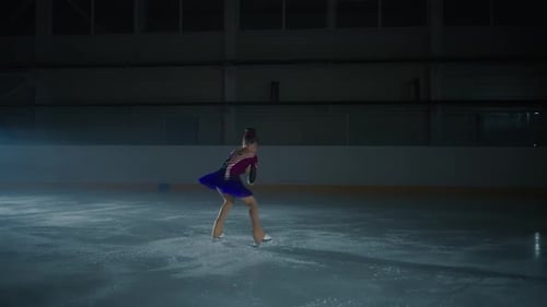 Girl Figure Skating on Ice Rink at Night