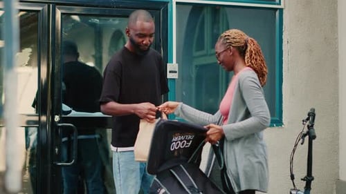 Female Delivery Person Giving Food Package to Client