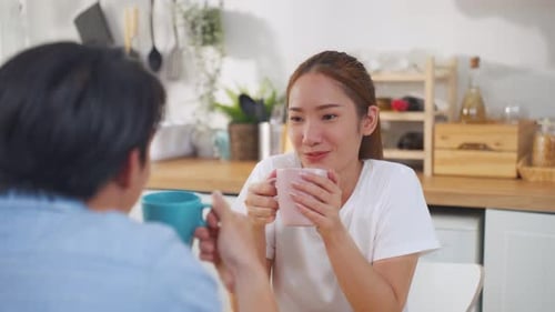 Couple Chatting and Drinking in Modern Kitchen