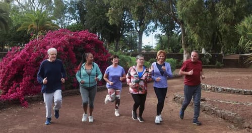 Active senior friends enjoying a fun run together at the park in London
