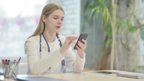 Doctor Browsing Smartphone in Clinic
