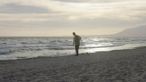 Young man using metal detector a the beach