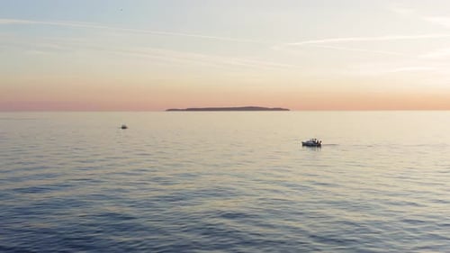 Aerial view of small boats in the mediterranean sea during a bautiful red sunset