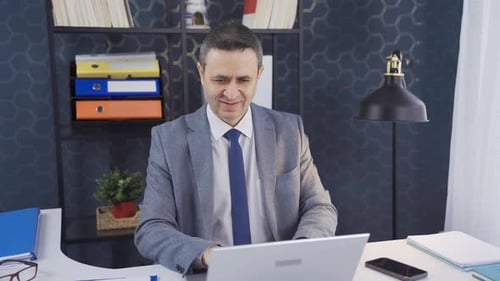 Office worker man working on laptop at his desk.