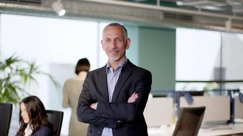 Confident entrepreneur standing in office with arms crossed
