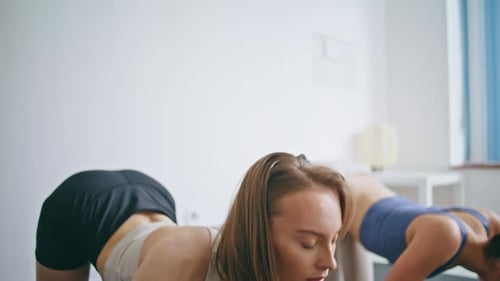 Two Women Doing Yoga Indoors