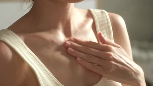 Une femme applique une crème hydratante sur les éruptions cutanées enflammées