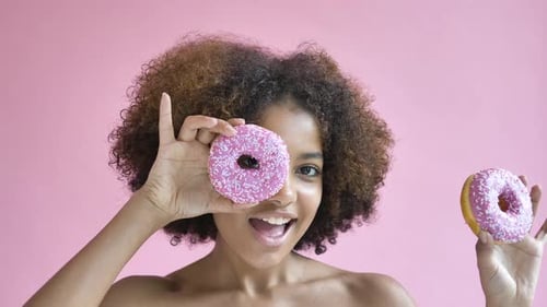 Cheerful Woman Playing with Pink Donuts