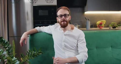Man Gives Thumbs Up on Green Couch