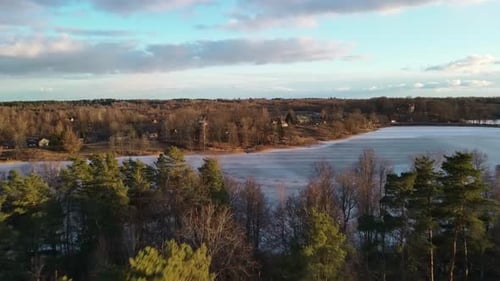 Aerial view of spring lake landscape and small village in sunny evening. Top view of beautiful Europ