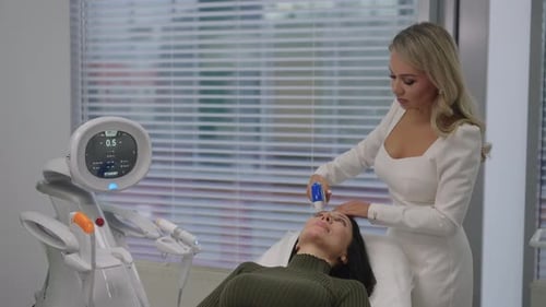 Woman receiving facial treatment in modern medical clinic