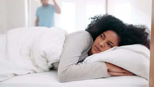 Woman Lying in Bed as Man Gestures
